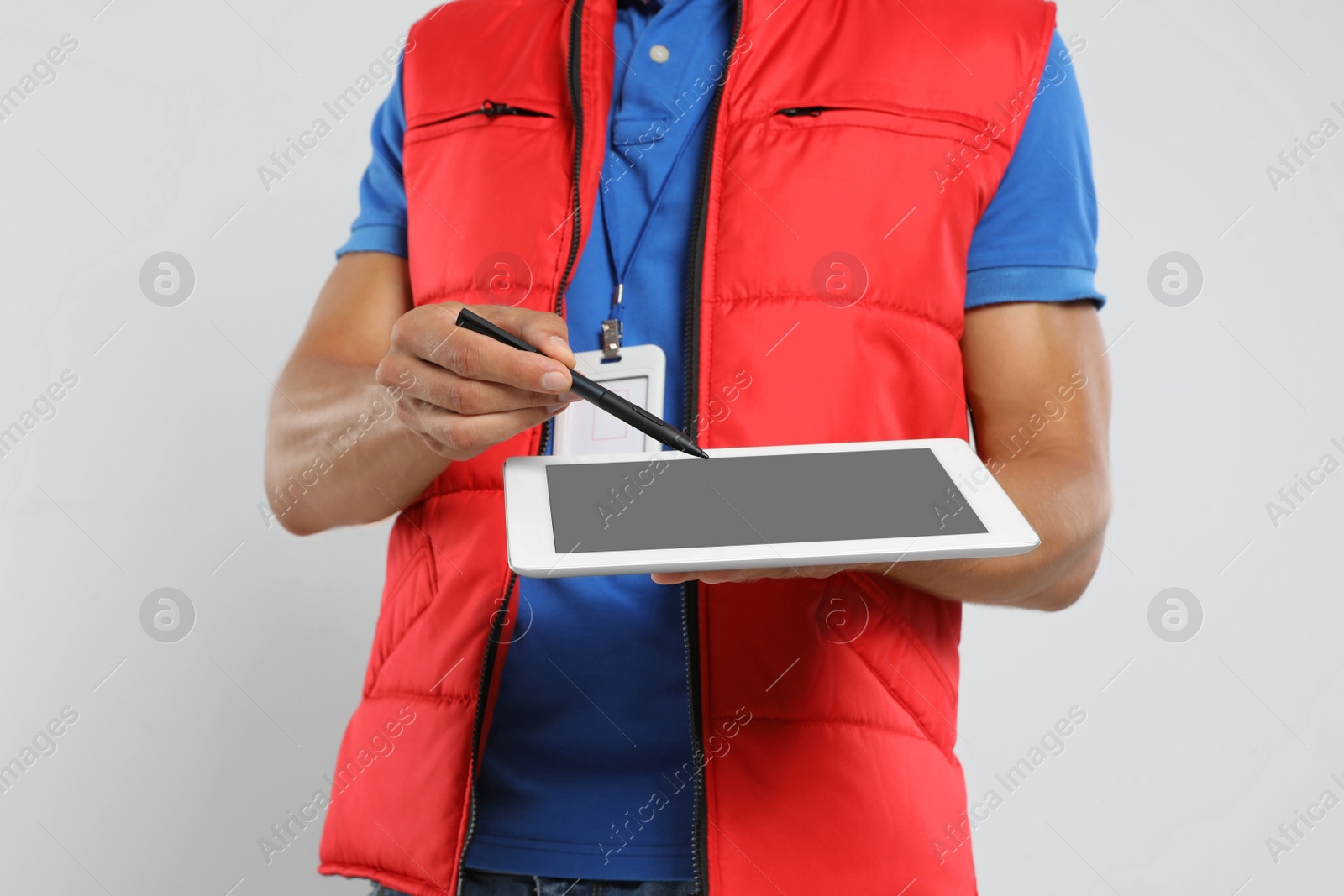 Photo of Young courier with tablet on white background, closeup