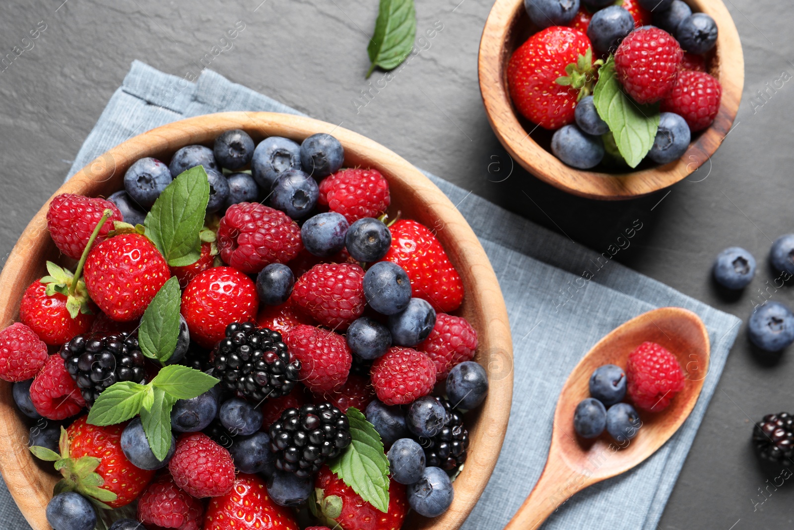 Photo of Many different fresh ripe berries on black table, flat lay