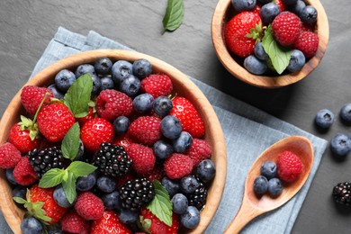 Many different fresh ripe berries on black table, flat lay