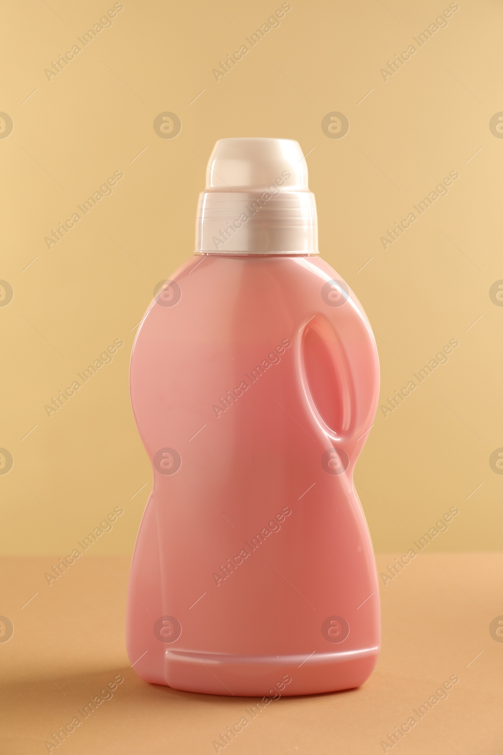 Photo of Bottle with detergent on beige background. Cleaning supply