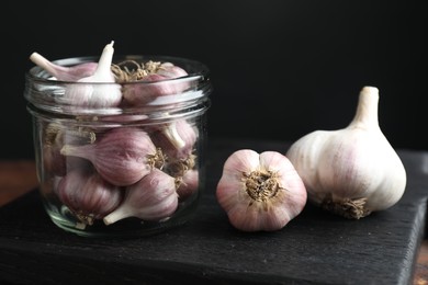Many fresh garlic bulbs on black board, closeup