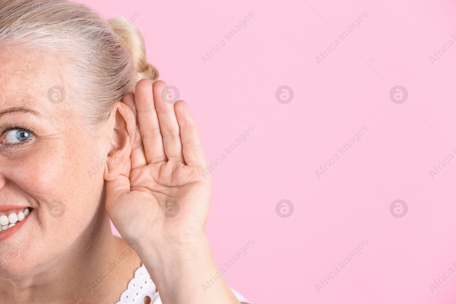 Photo of Mature woman with hearing problem on color background, closeup. Space for text