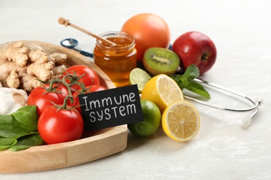 Card with phrase Immune System, stethoscope and fresh products on light table