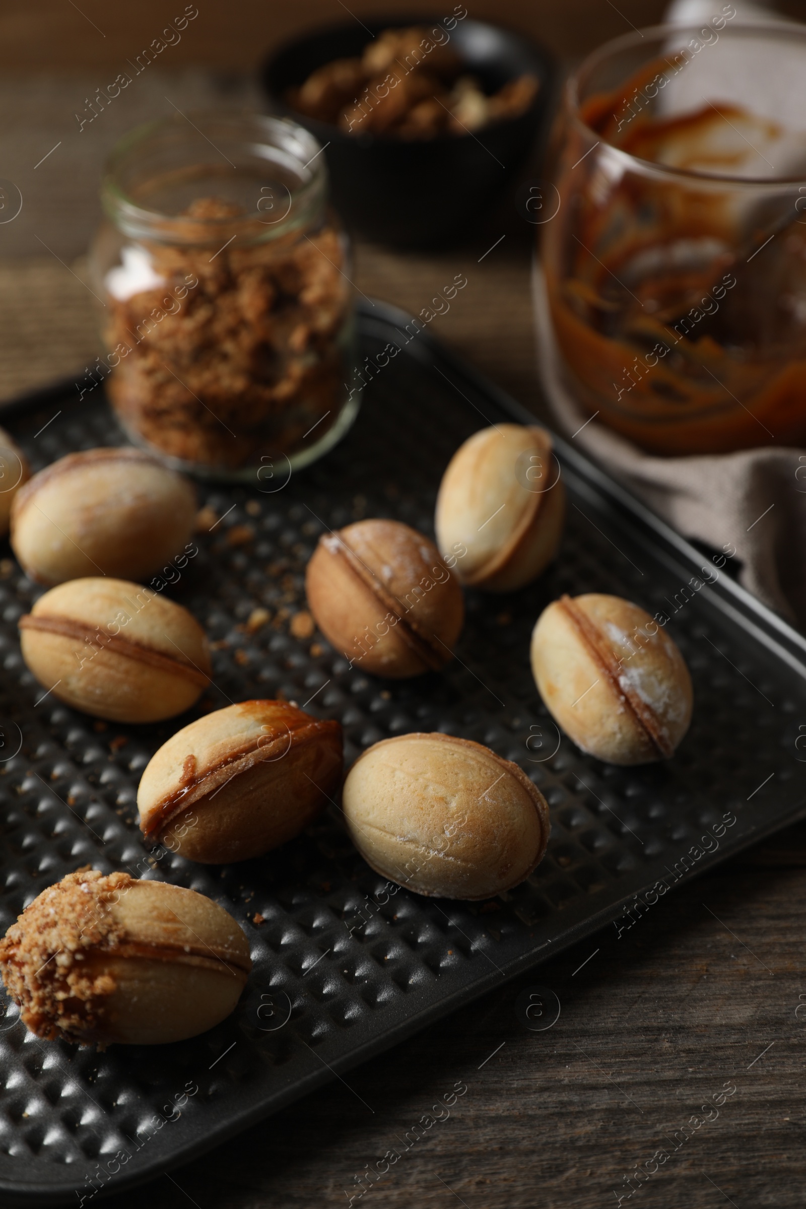 Photo of Freshly baked homemade walnut shaped cookies on wooden table, closeup