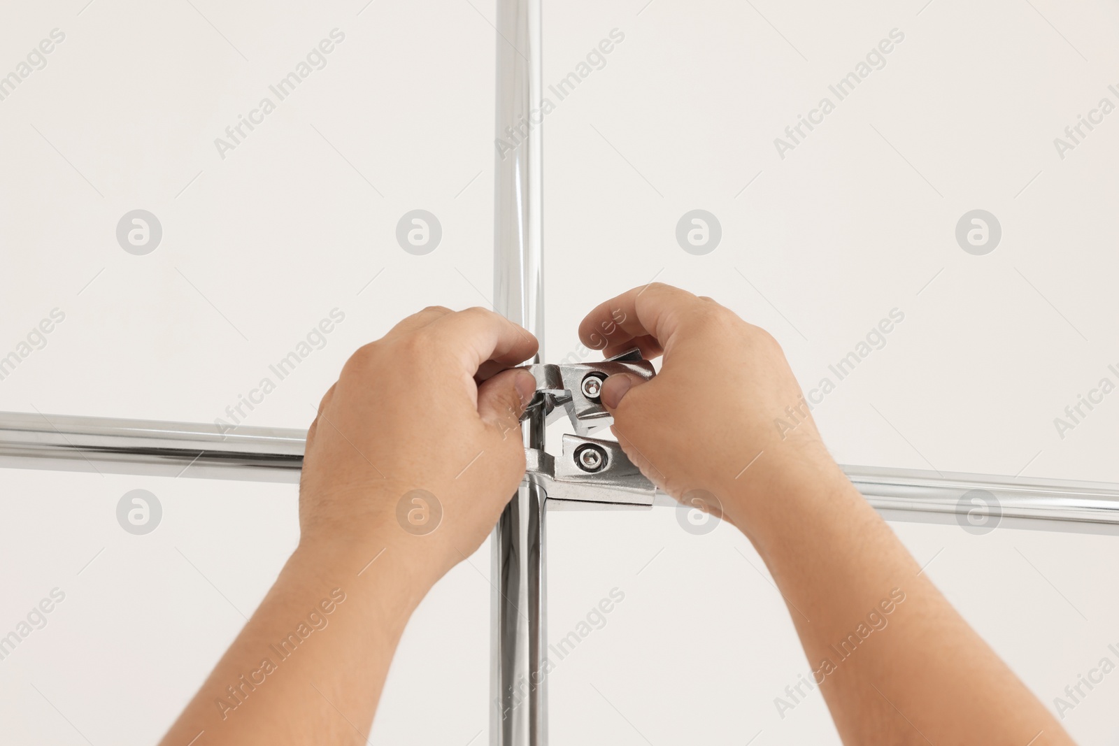 Photo of Worker installing new metal pipes indoors, closeup