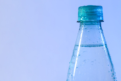 Photo of Plastic bottle of pure water on color background, closeup. Space for text