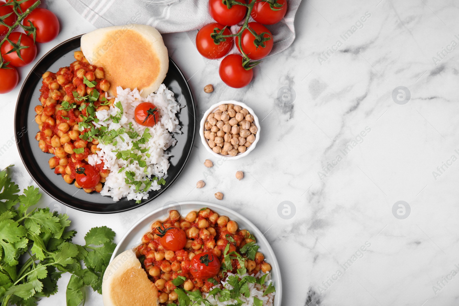 Photo of Delicious chickpea curry with rice served on white marble table, flat lay. Space for text