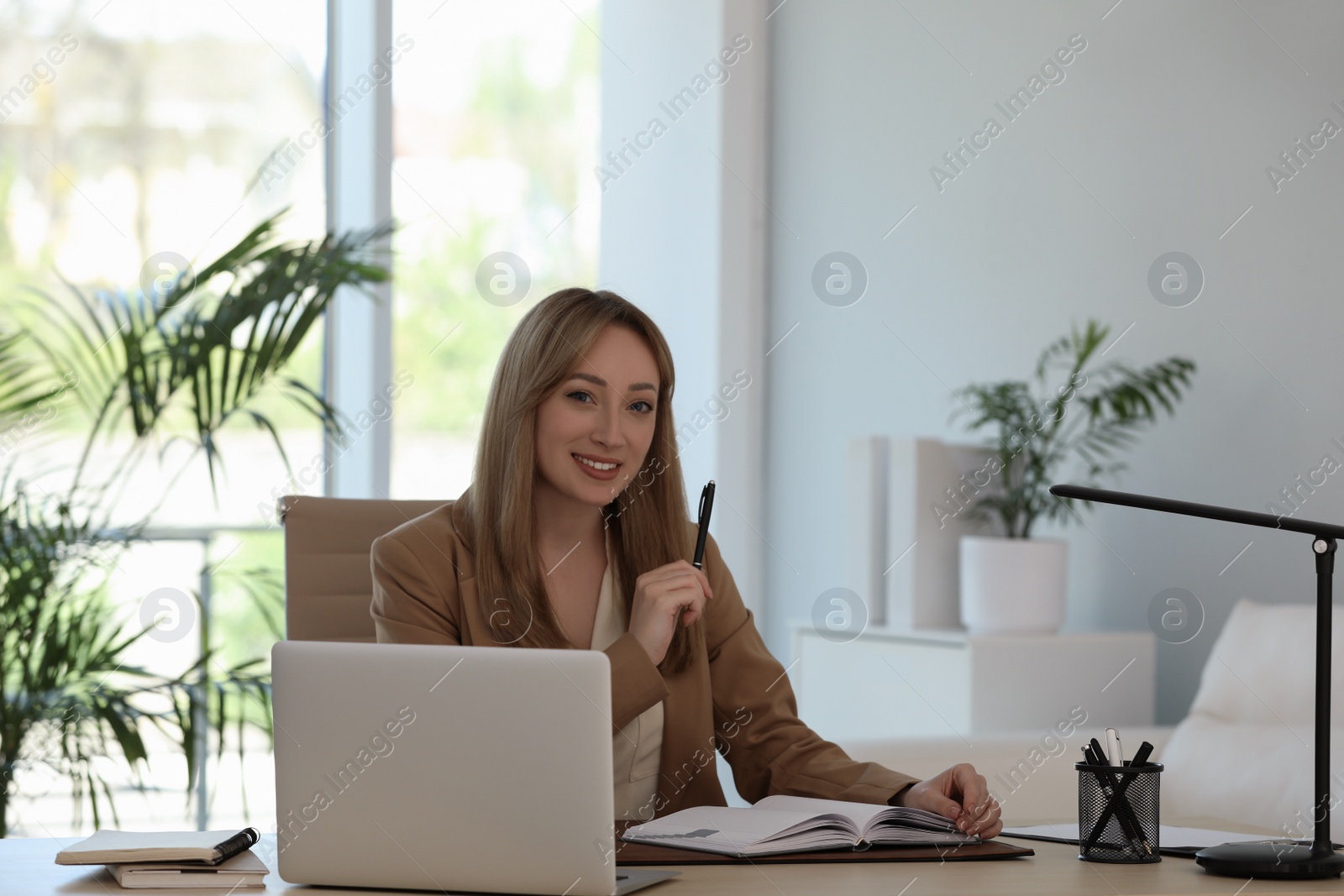 Photo of Secretary working at wooden table in office