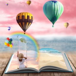 Image of Fantasy worlds in fairytales. Book, hot air balloons and pink sky over misty sea on background