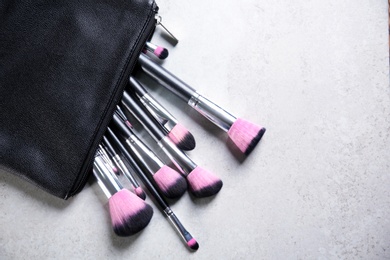 Flat lay composition with professional makeup brushes on light background