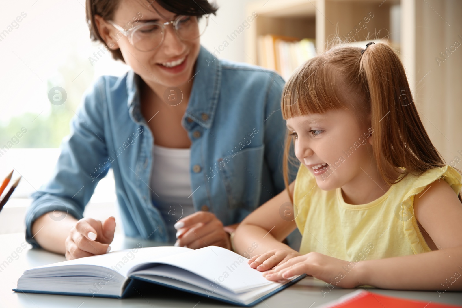 Photo of Female teacher helping child with assignment at school