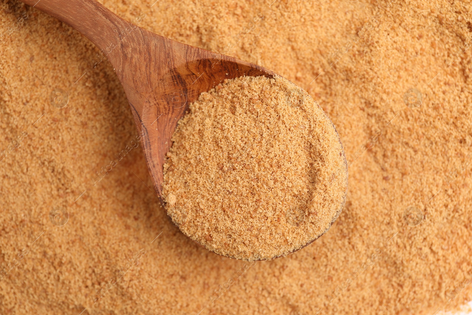 Photo of Brown coconut sugar and spoon, top view