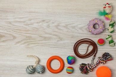 Photo of Flat lay composition with pet leash and toys on white wooden background, space for text