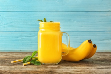 Photo of Mason jar with delicious detox smoothie on table