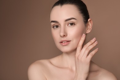 Portrait of beautiful young woman on brown background. Space for text