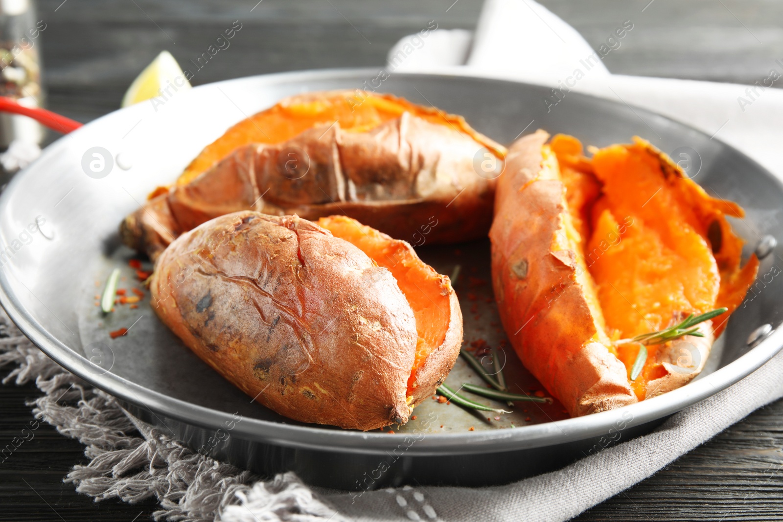 Photo of Dish with baked sweet potatoes on table, closeup