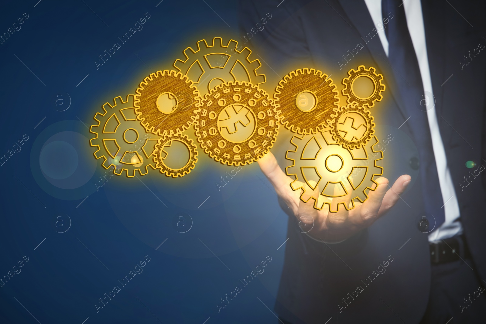 Image of Businessman demonstrating gear mechanism on blue background, closeup