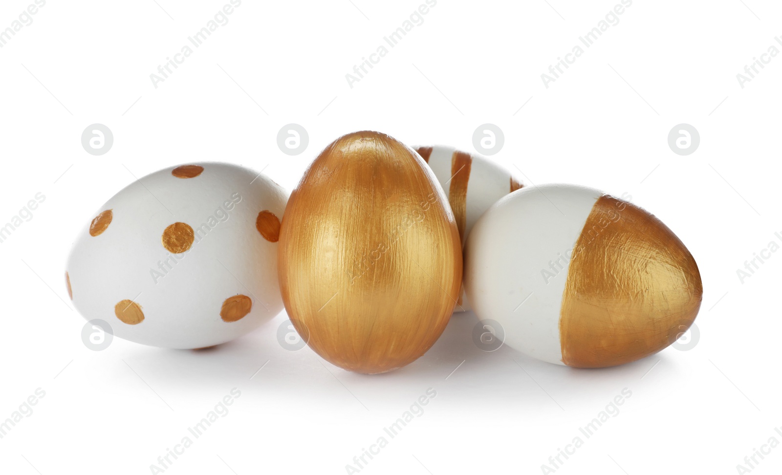 Photo of Set of traditional Easter eggs decorated with golden paint on white background