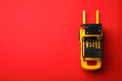 Photo of Top view of toy forklift on red background, space for text. Logistics and wholesale concept