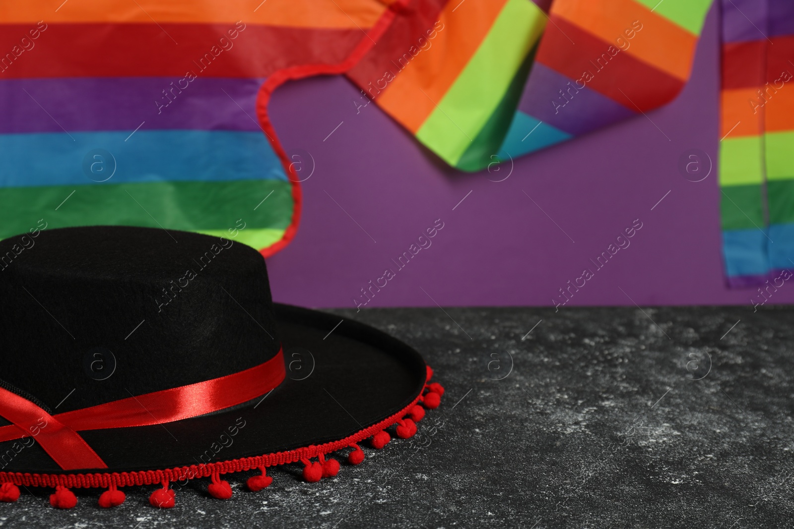 Photo of Black Flamenco hat on dark textured table, closeup. Space for text