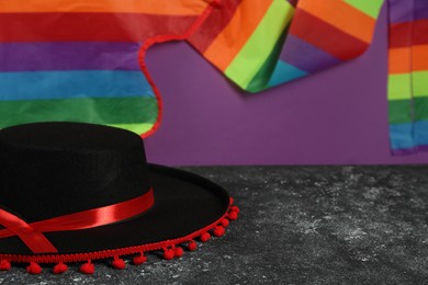 Black Flamenco hat on dark textured table, closeup. Space for text