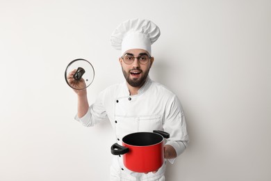 Professional chef with cooking pot on white background