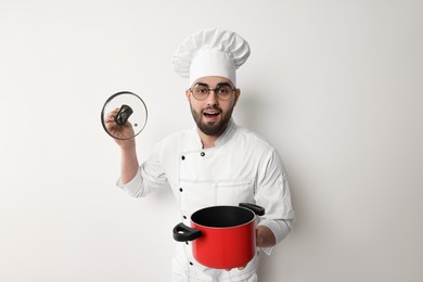 Photo of Professional chef with cooking pot on white background