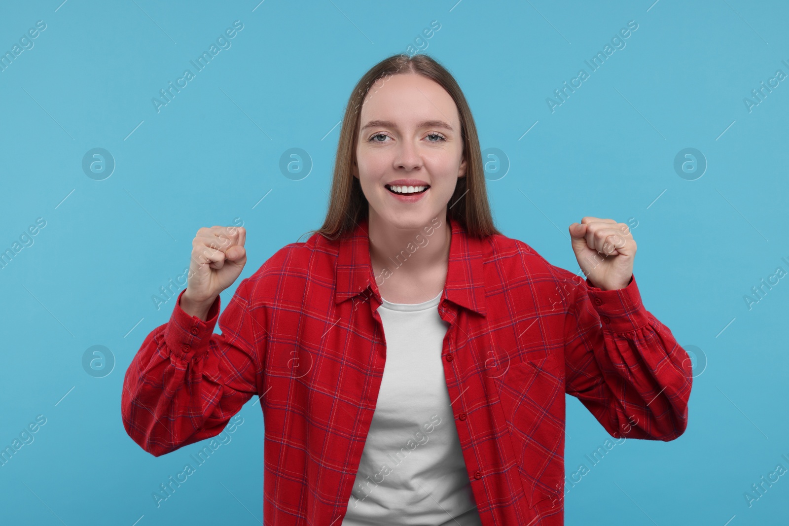 Photo of Emotional sports fan celebrating on light blue background