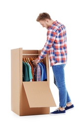 Young man near wardrobe box on white background