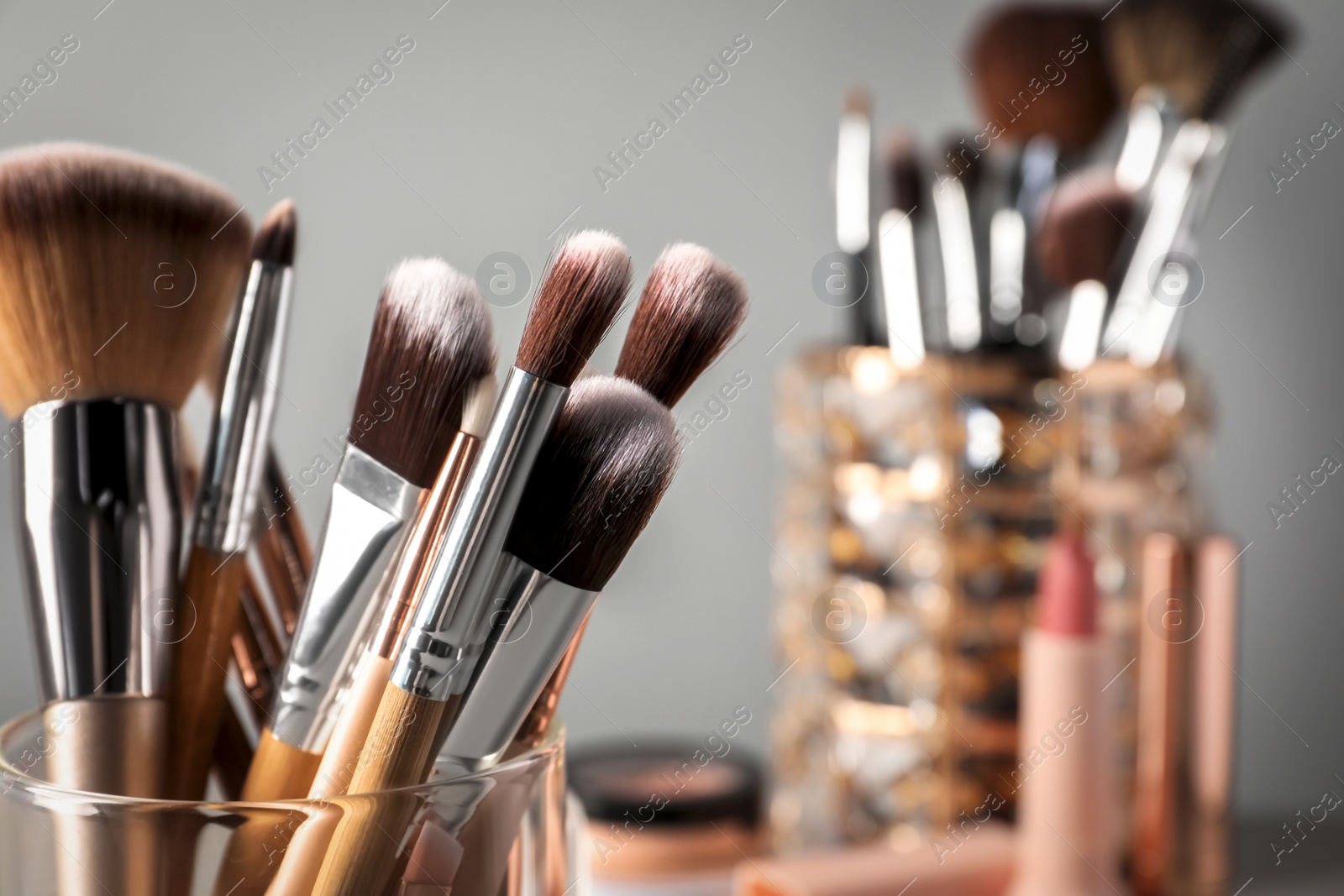 Photo of Set of professional makeup brushes on grey background, closeup. Space for text