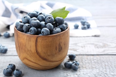 Photo of Tasty fresh blueberries on wooden table, closeup. Space for text