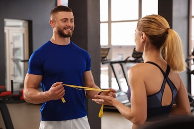 Trainer having discussion with woman in gym