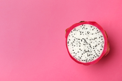 Photo of Half of delicious ripe dragon fruit (pitahaya) on pink background, top view. Space for text