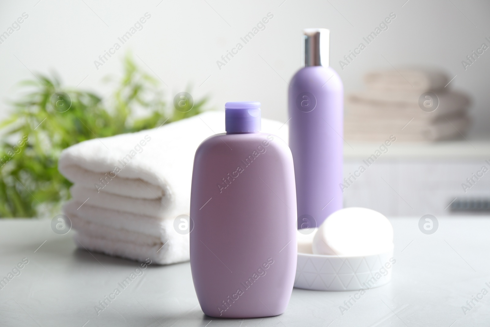 Photo of Fresh towels and toiletries on light grey stone table