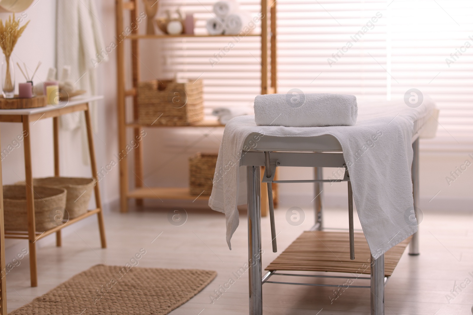 Photo of Comfortable massage table with clean towels in spa center