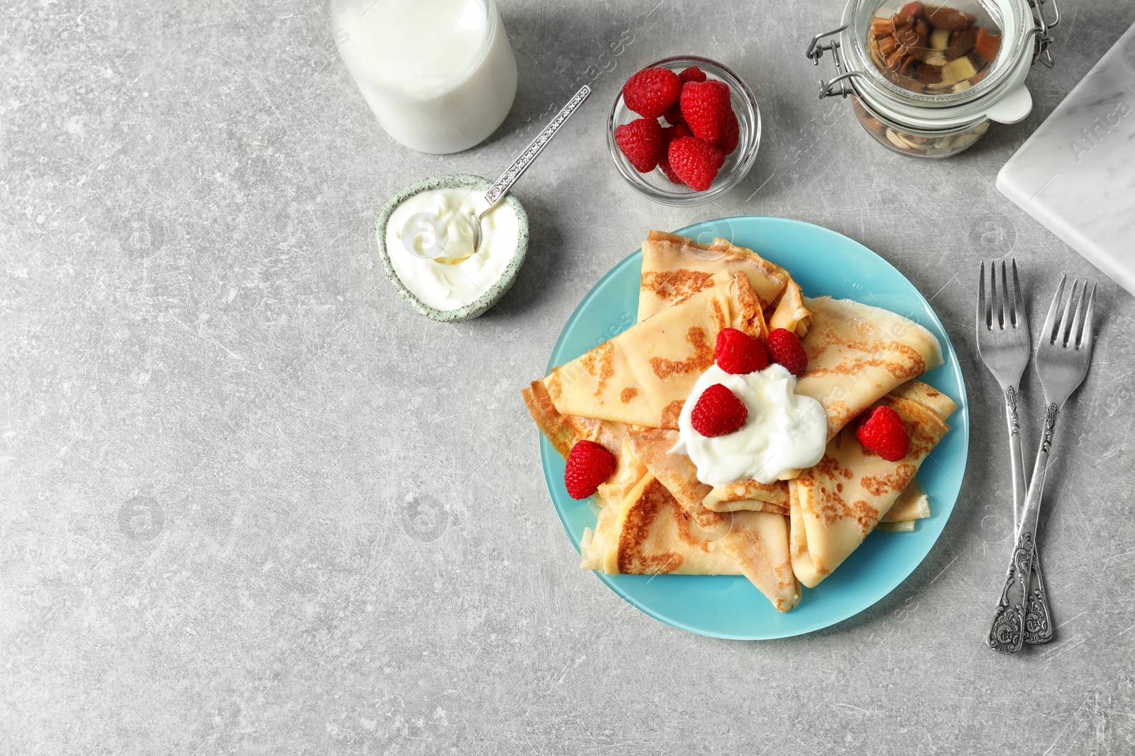 Photo of Thin pancakes with berries and cream on plate, top view