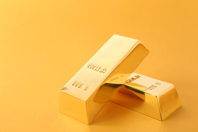 Precious shiny gold bars on color background. Space for text