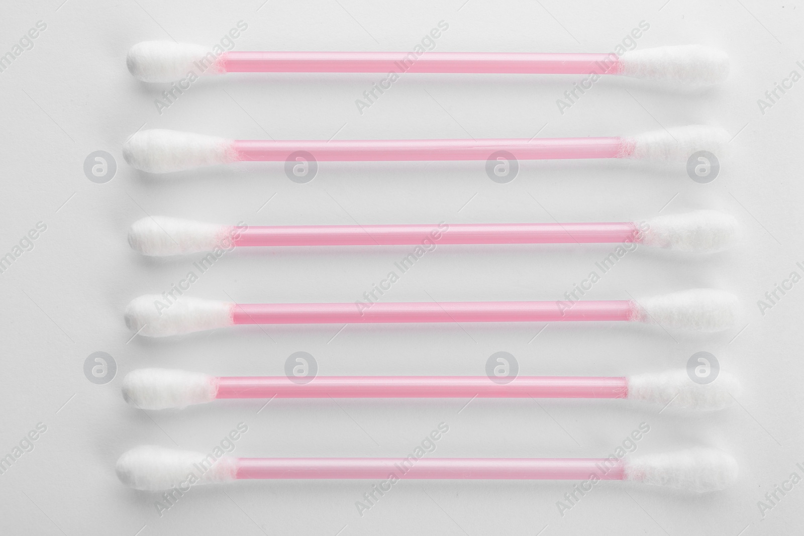 Photo of Pink plastic cotton swabs on white background, top view