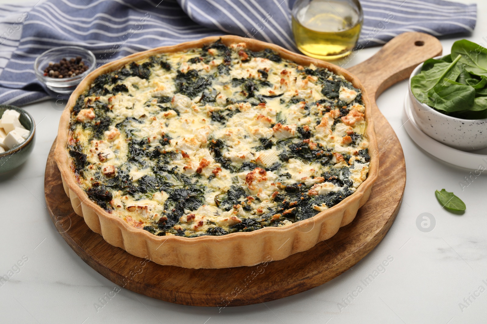 Photo of Delicious homemade spinach quiche on white table
