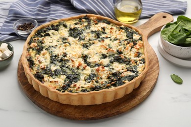 Delicious homemade spinach quiche on white table