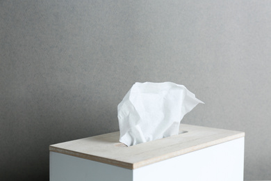 Photo of Holder with paper tissues on grey background