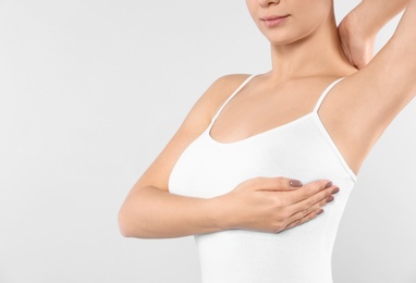 Photo of Woman checking her breast on white background, closeup