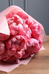 Photo of Bouquet of beautiful pink peonies on wooden table, closeup