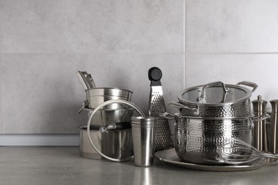 Photo of Set of different cooking utensils on grey countertop in kitchen