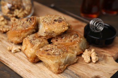 Photo of Eastern sweets. Pieces of tasty baklava on wooden table, closeup