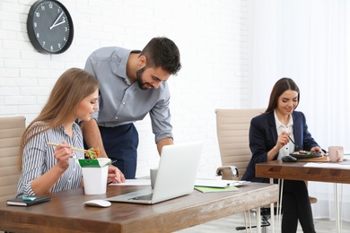 Photo of Office employees having lunch at workplace. Food delivery