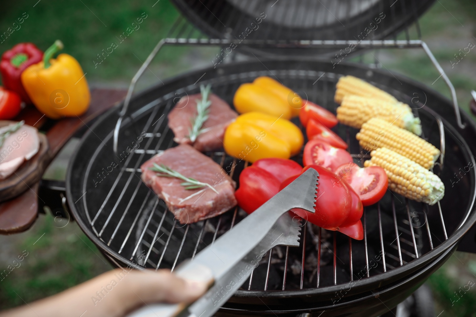 Photo of Man cooking food on barbecue grill outdoors, closeup