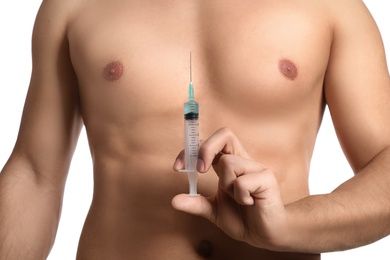 Athletic man with syringe on white background, closeup. Doping concept