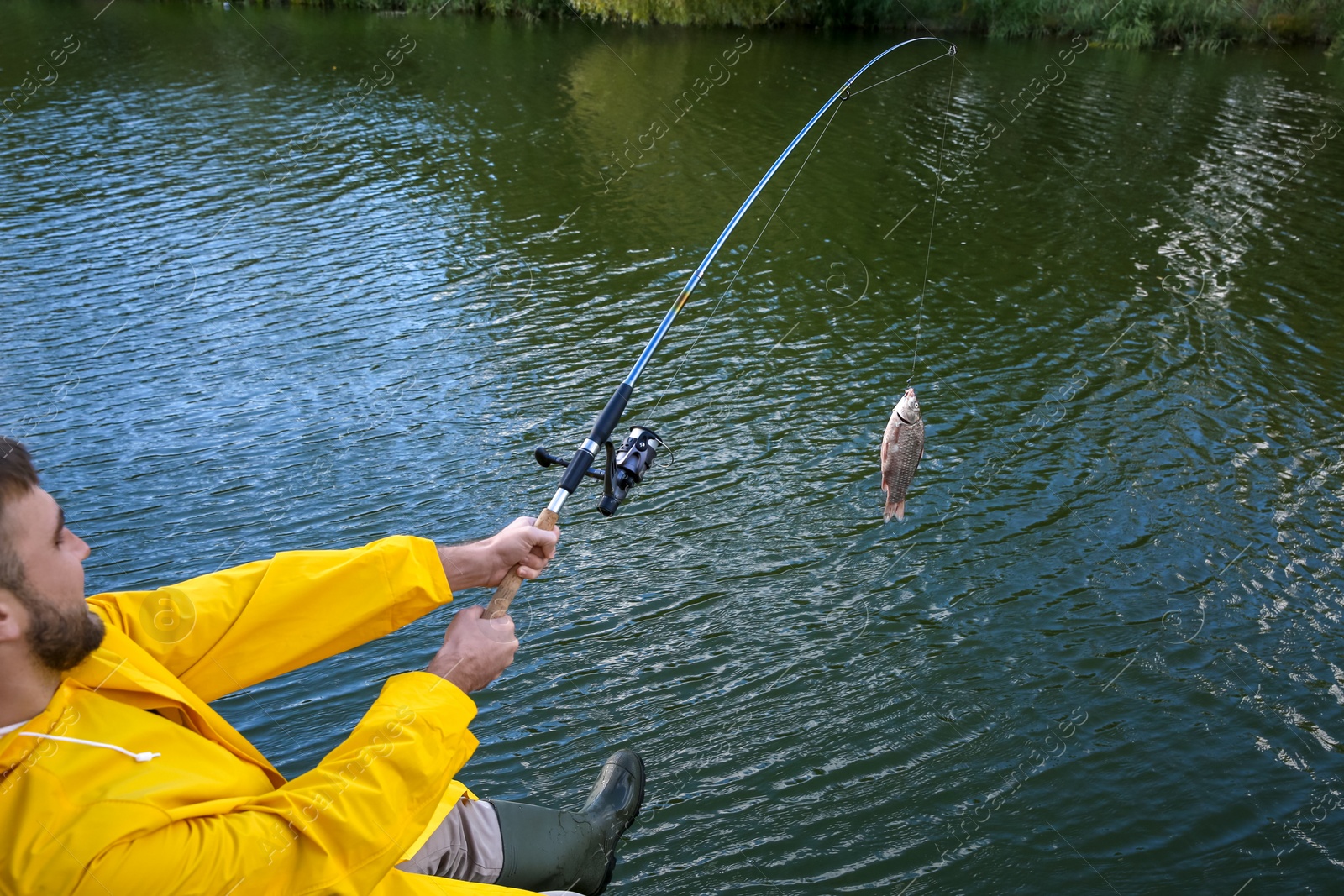 Photo of Man with rod fishing at riverside. Recreational activity