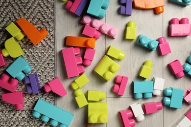 Photo of Colorful plastic building blocks on floor, flat lay